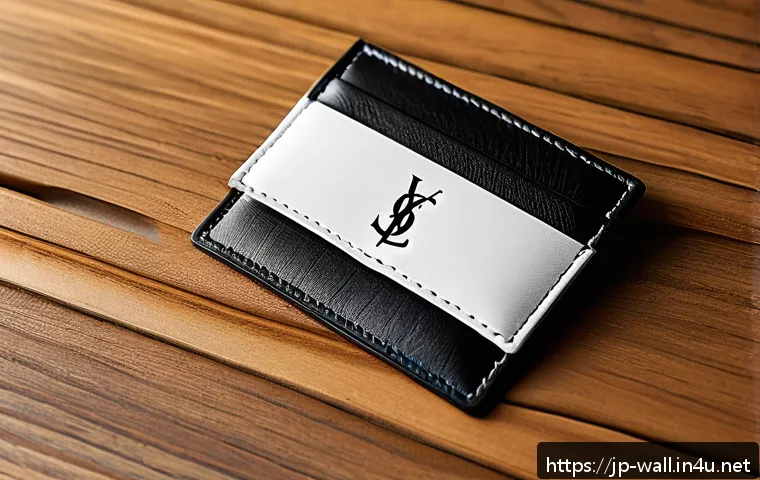 생로랑 모노그램 카드홀더 vs 루루 지갑 - A sleek, minimalist luxury card holder featuring the iconic YSL monogram logo prominently displayed ...